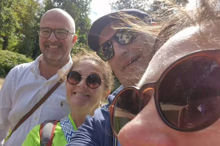 Group of four friends smiling outdoors on a sunny Brussels walking tour