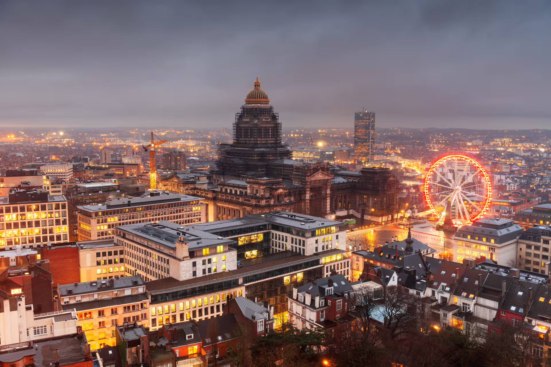 Evening skyline over Brussels city center with illuminated dome and ferris wheel, featured on 1-day audio walking tour