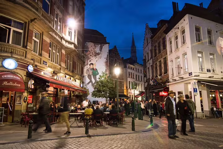 Evening ambiance in Brussels with lively street cafes and iconic murals on a private local walking tour off the beaten path.