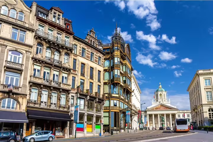 Historic Brussels street with ornate Art Nouveau buildings and Saint Jacques sur Coudenberg church in background