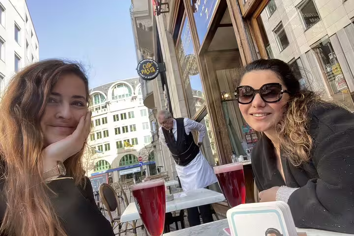 Two women enjoying red drinks at an outdoor café terrace in Brussels Old Town