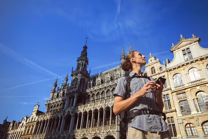 Tourist explores the architectural charm of Brussels during a private local walking tour on a sunny day.