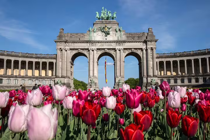 Vibrant tulips bloom in front of the iconic Cinquantenaire Arch in Brussels, a highlight of the private local walking tour.