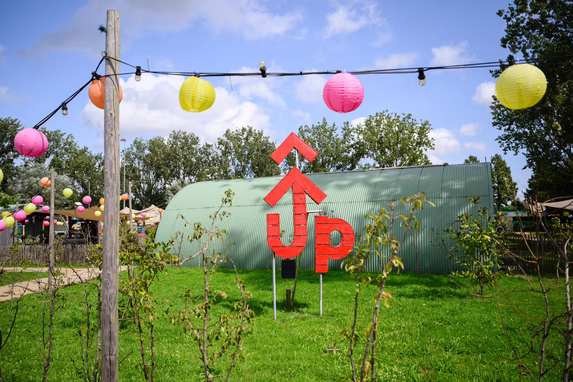 Outdoor bubble football venue near Amsterdam with UP Events sign and colorful lanterns, ideal for group bookings