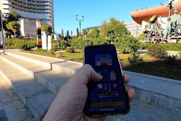 Exploring Bucharest 1989 Revolution sites with a self-guided tour app showing historical landmarks on a sunny day.