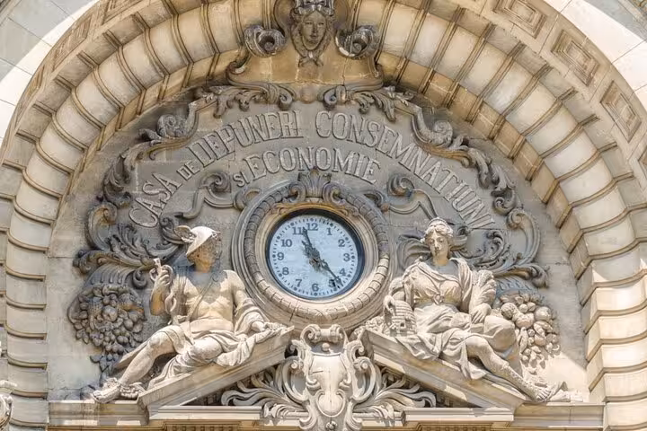 Ornate facade of Casa de Depuneri Consemnatiuni si Economie building in Bucharest with clock and stone sculptures