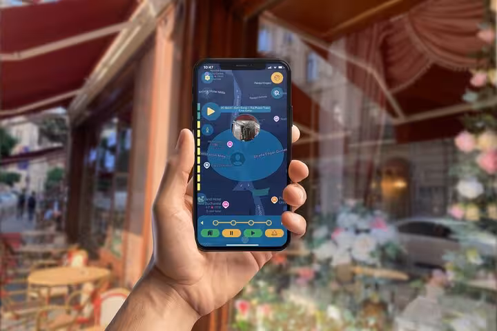 Hand holding smartphone displaying Bucharest self-guided walking tour mobile app with interactive map