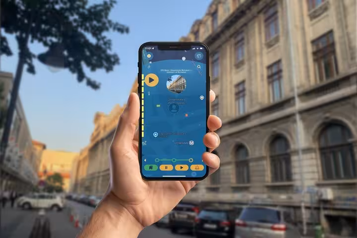 Hand holding smartphone with self-guided walking tour app showing Bucharest map and University landmark