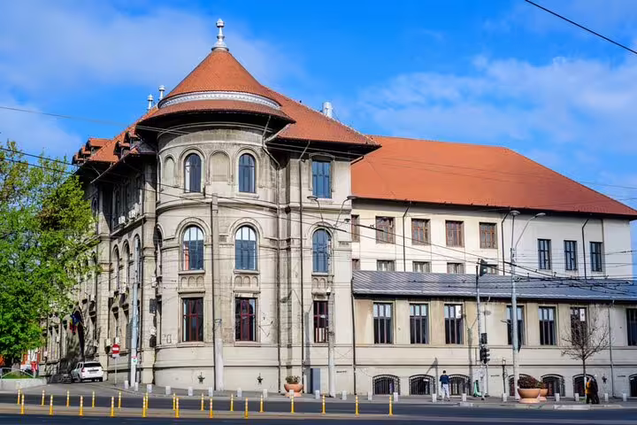 Historic ornate building with terracotta roof and arched windows in Bucharest Old Town