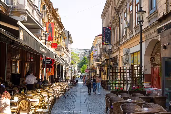 Pedestrian street lined with outdoor cafes and historic buildings in Bucharest old town