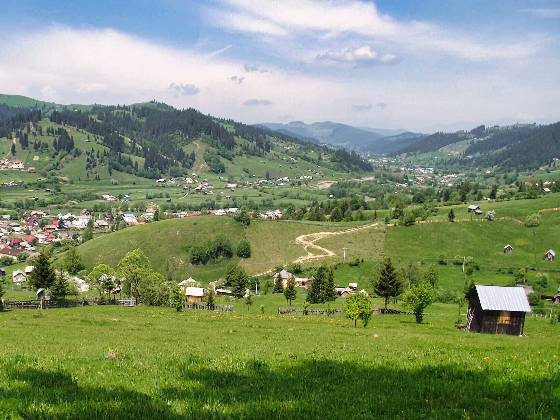 Scenic Bucovina countryside with rolling green hills and traditional village on a 2-day monastery tour