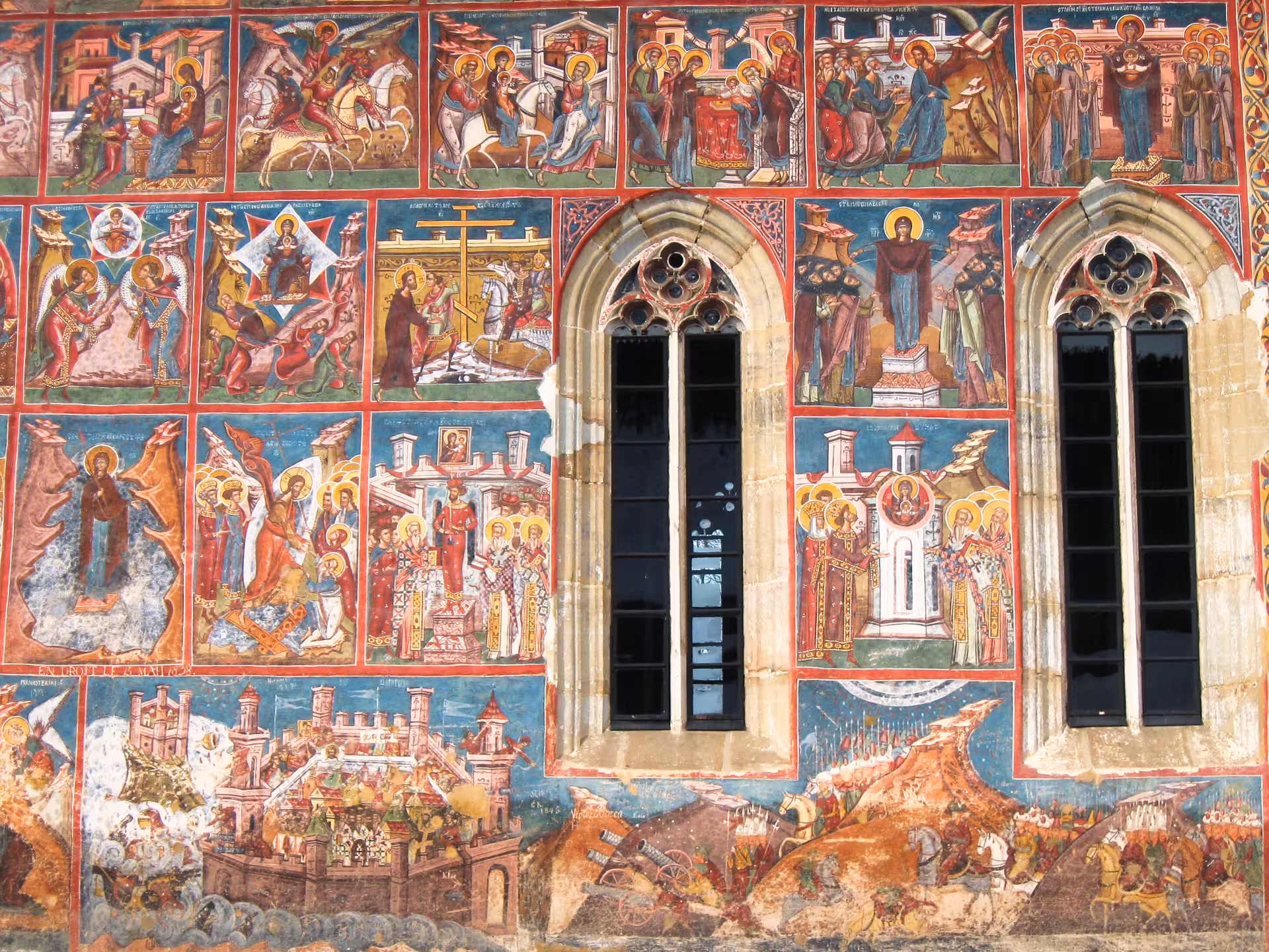 Colorful Byzantine frescoes covering Bucovina monastery walls visited during Easter egg painting Romania tour