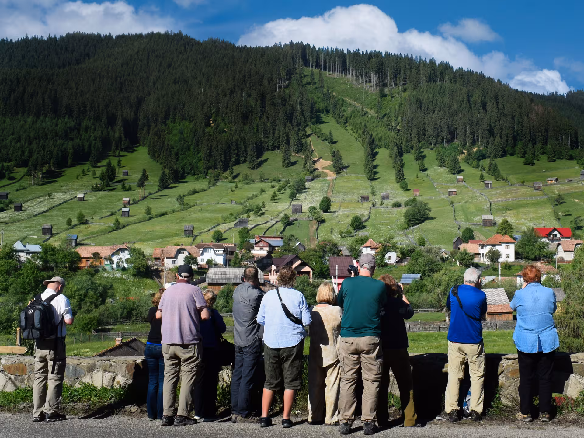 Tourists admiring scenic Bucovina village landscape with lush green hills on a 2-day monastery tour