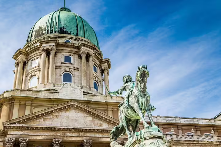 Buda Castle dome and equestrian statue in Budapest under blue sky