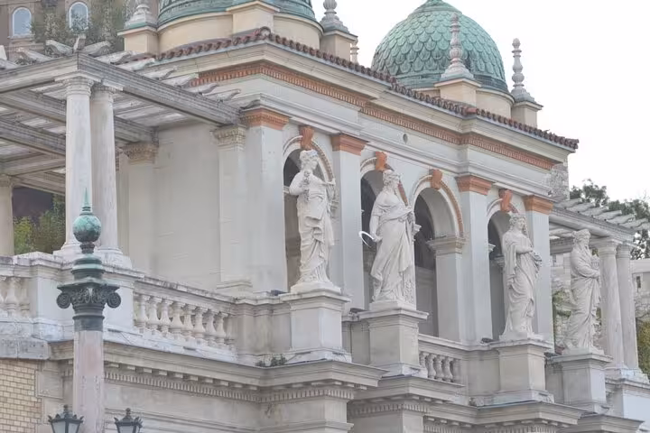 Classical statues and green domed towers on Buda Castle facade, Budapest