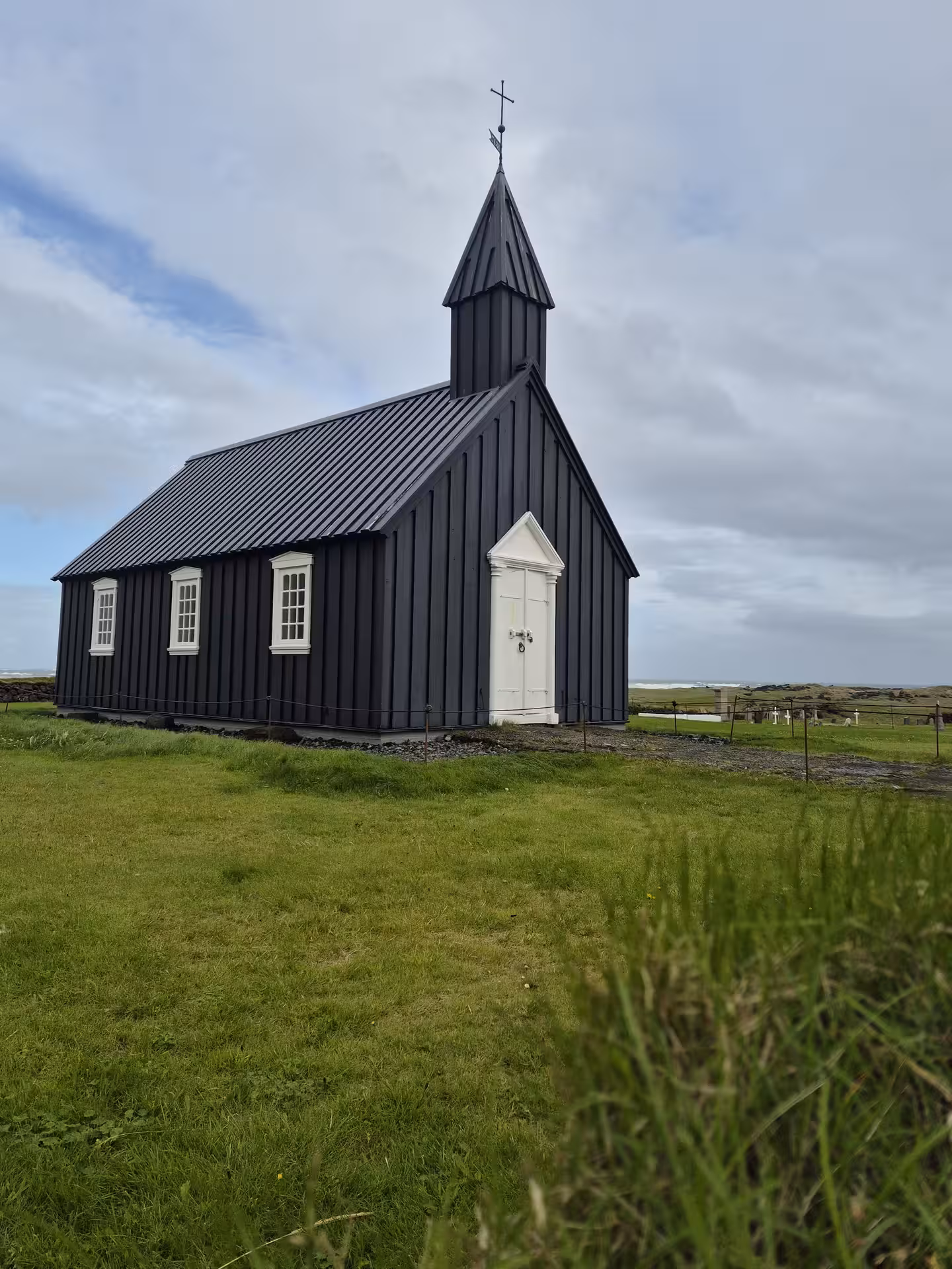 Black wooden Búðakirkja church with white door and steeple on Snæfellsnes Peninsula, Iceland