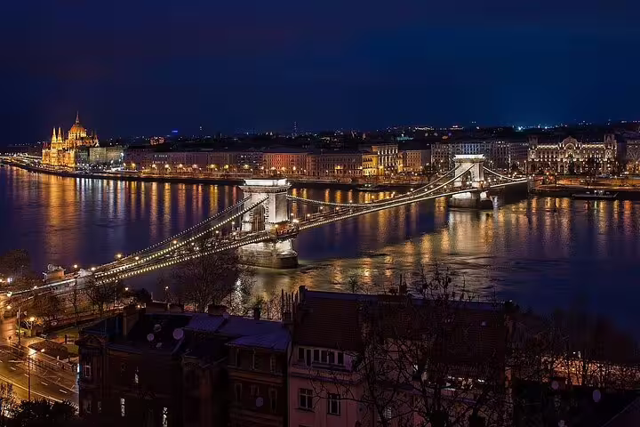 Budapest Chain Bridge illuminated at night with Parliament building and Danube River reflections
