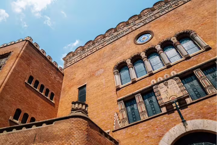 Ornate red brick historic building with arched windows and decorative facade in Budapest Jewish Quarter