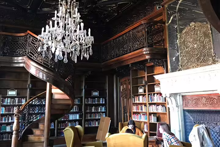 Ornate Budapest library interior with spiral staircase and chandelier on a private modern city tour