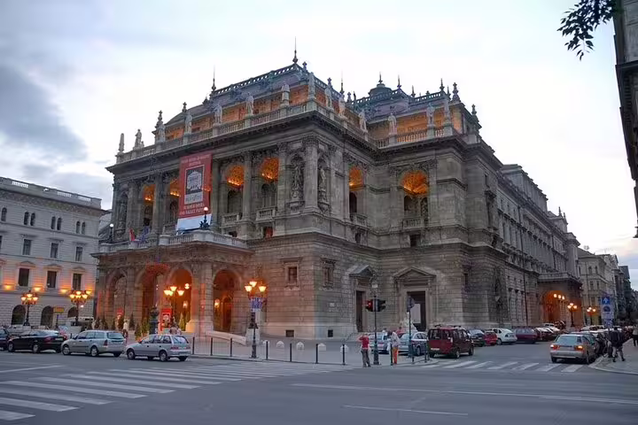 Stunning view of the illuminated Hungarian State Opera House at dusk, highlighting Budapest's vibrant night tour attractions.