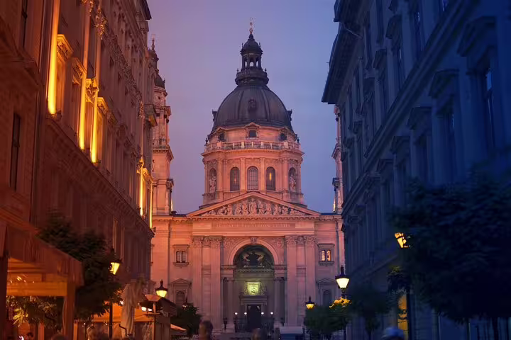 St. Stephen's Basilica illuminated at dusk, showcasing Budapest's architectural beauty and vibrant nightlife during the evening tour.