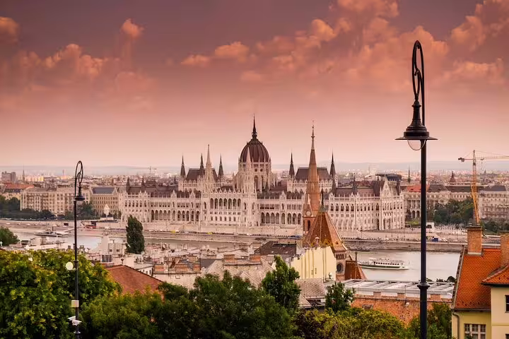 Panoramic view of Budapest Parliament Building along the Danube River at sunset