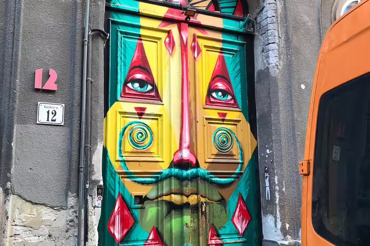 Colorful face graffiti painted on a doorway in Budapest, a highlight stop on the street art walking tour