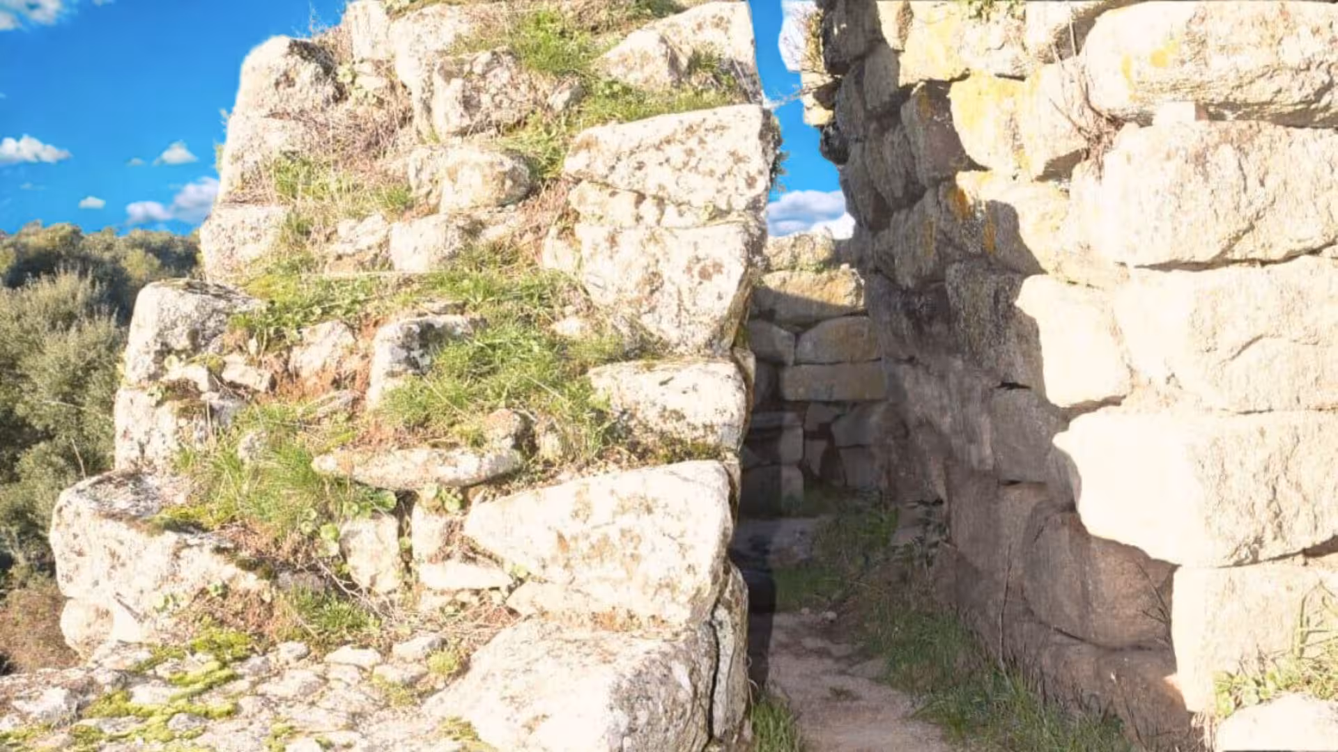 Discover moss-covered stone walls in the serene Loelle archaeological site, part of Buddusò guided tours.