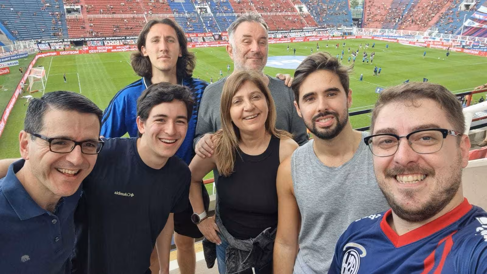 Group selfie at Buenos Aires football stadium during matchday tour with locals and pre-game atmosphere