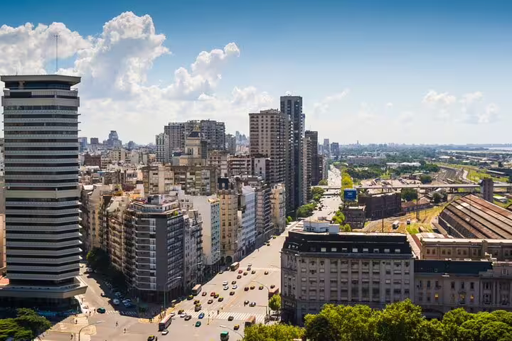 Aerial view of Buenos Aires cityscape with wide boulevard, tall buildings, and busy streets on a sunny day