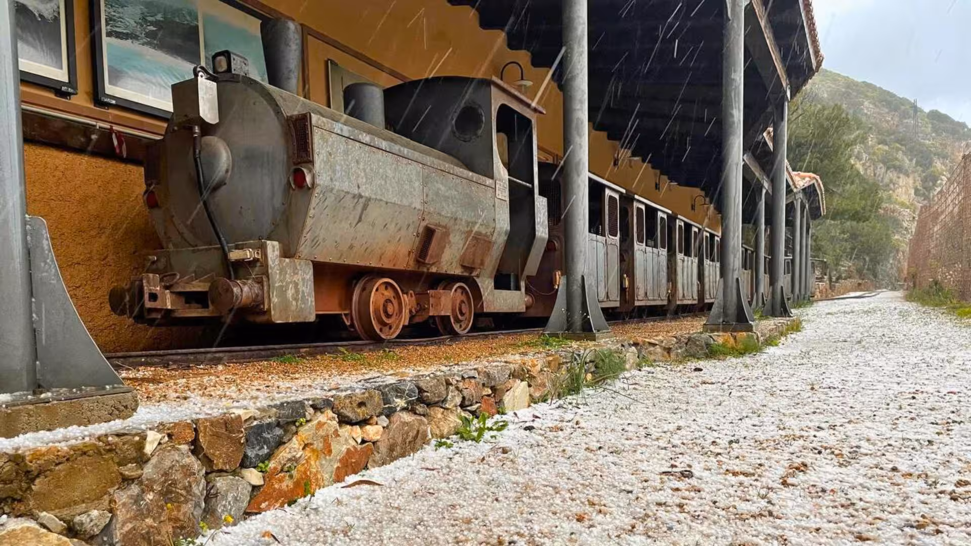 Historic mining train at Galleria Henry tunnel in Buggerru, showcasing industrial heritage and adventure tourism.