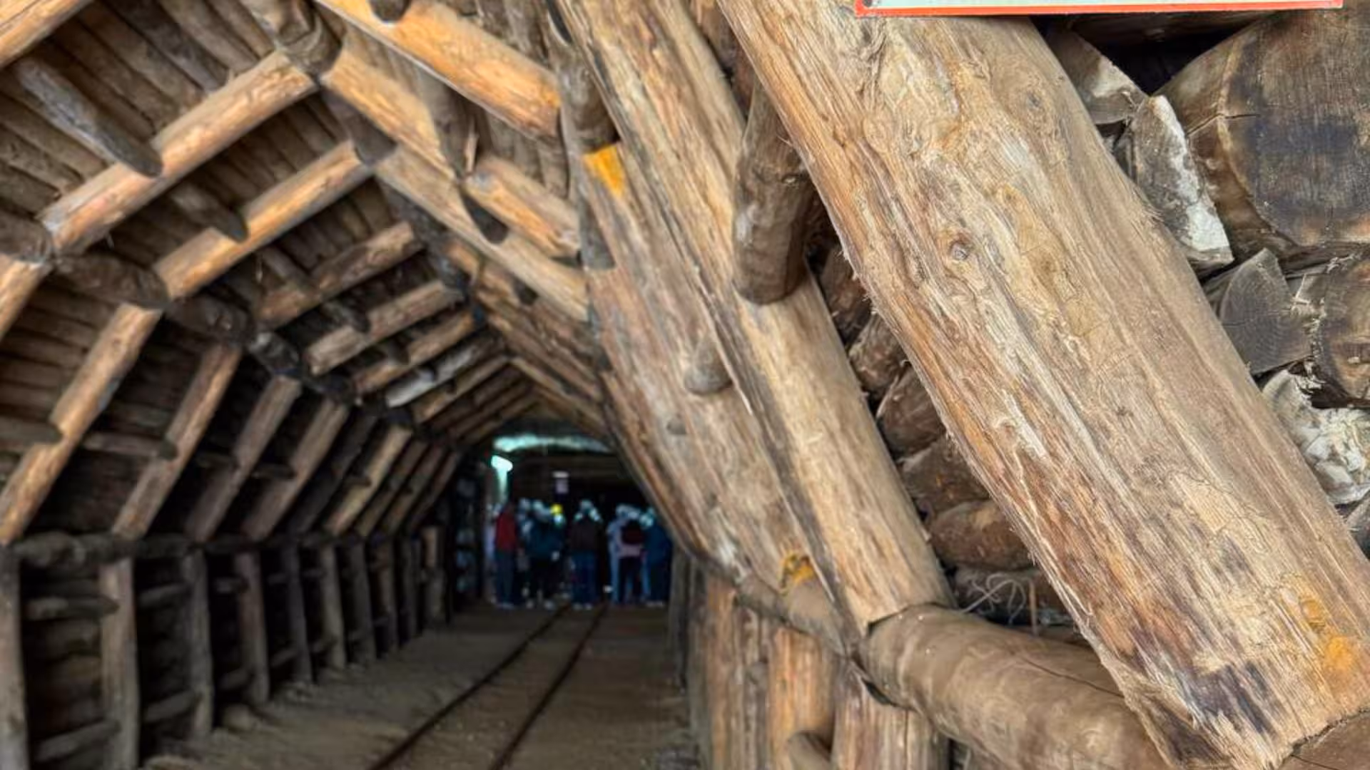 Visitors exploring the wooden-lined Galleria Henry mining tunnel, a key historic attraction in Buggerru tours.