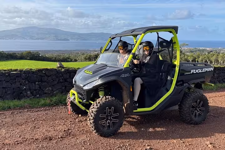 Two people enjoy a scenic buggy ride with ocean views on an adventure tour in Mount Pico.