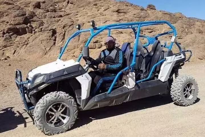 Driver in 4x4 dune buggy on rocky Sinai track during double buggy desert safari tour from Sharm El Sheikh