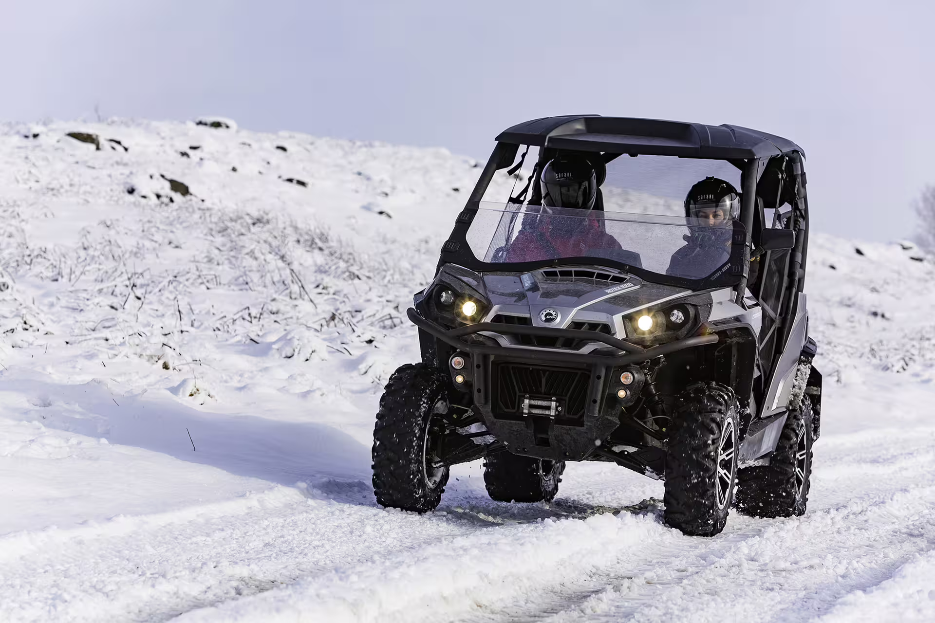 Two people driving a buggy through snowy terrain on a thrilling Golden Circle adventure tour, showcasing Iceland's winter landscapes.
