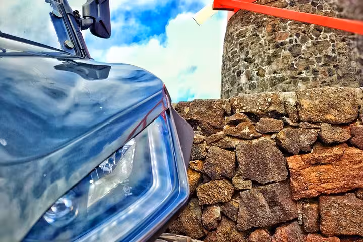 Close-up of a buggy parked beside a traditional stone wall on Pico Island, perfect for vineyard exploration tours.