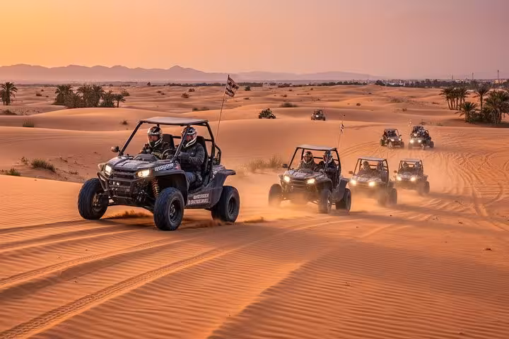Buggy Safari Sharm El Sheikh convoy racing over Sinai desert dunes at sunset, off-road adventure tour