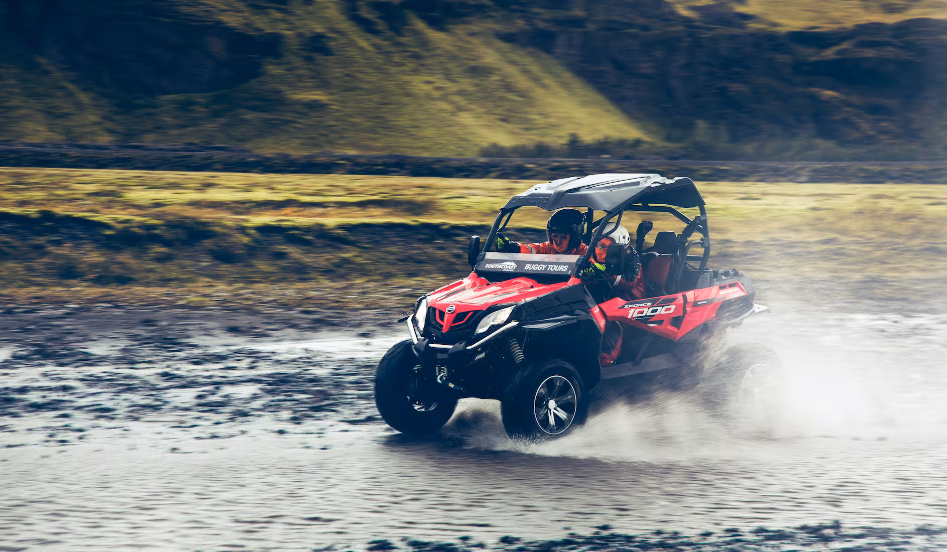 Red CFMOTO ZForce 1000 buggy splashing through a river in Thorsmork Iceland on a guided tour