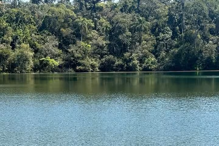 Serene lake surrounded by lush forest in Buraco do Padre, ideal for nature lovers seeking tranquility.