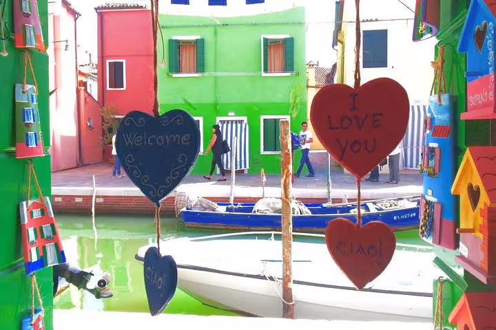Heart-shaped Burano canal decorations with boats and bright houses, ideal for a private Murano & Burano boat tour