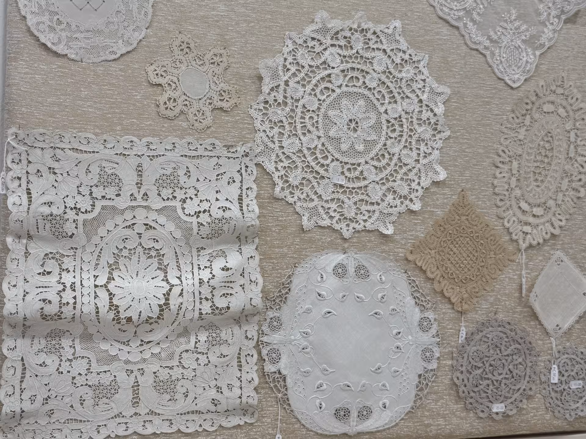 Collection of delicate, handcrafted lace designs displayed on Burano Island, showcasing intricate artisan skills.