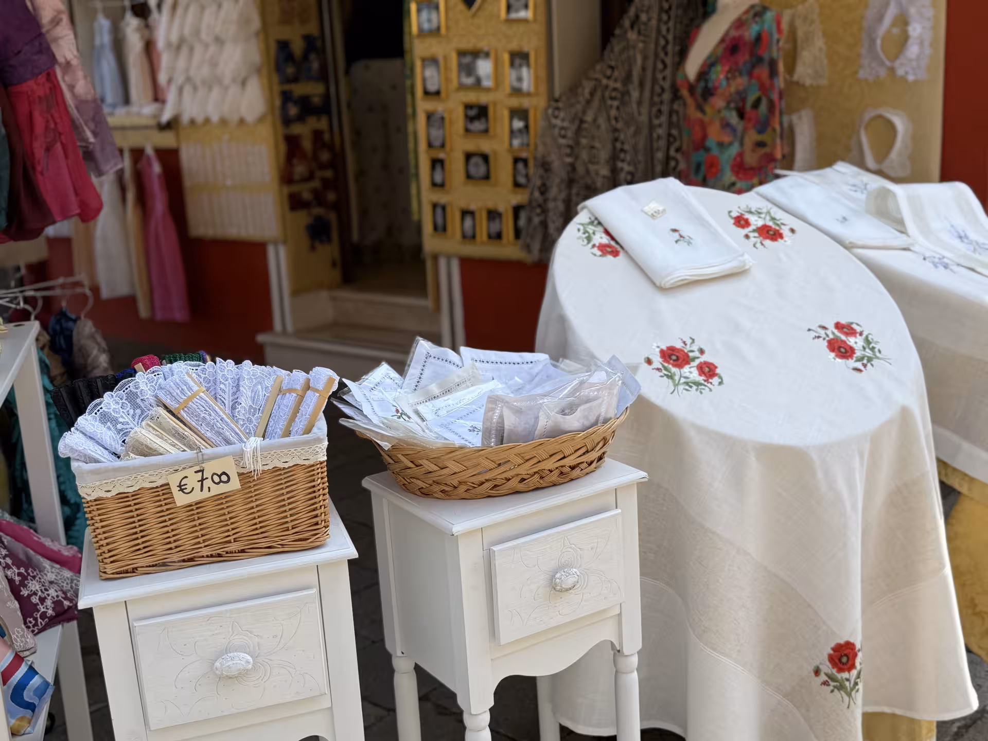 Charming Burano shop displays handmade lace and embroidered linens, highlighting local craftsmanship on the Grand Tour.