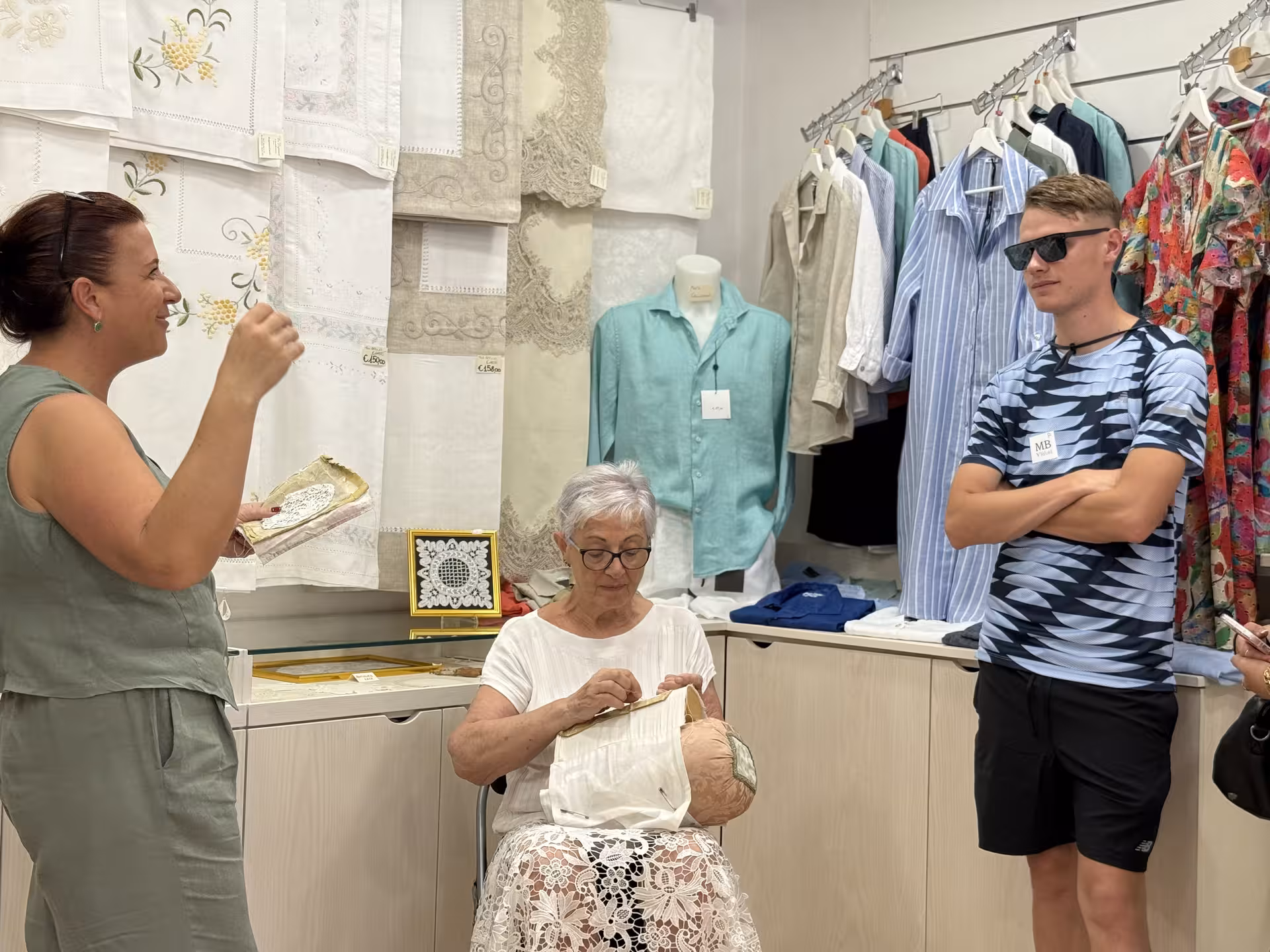 Tour group learning about intricate Burano lace-making techniques inside a shop on the Venice Islands tour.