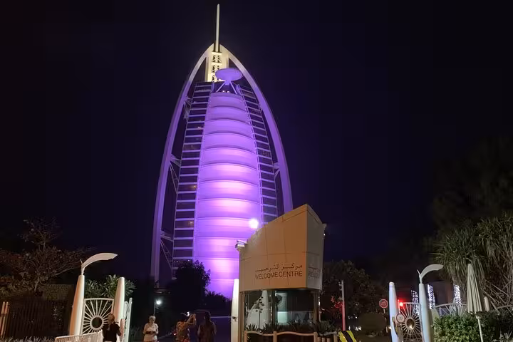 Burj Al Arab glowing purple at night, iconic photo stop on a private Dubai by night tour with fountain show