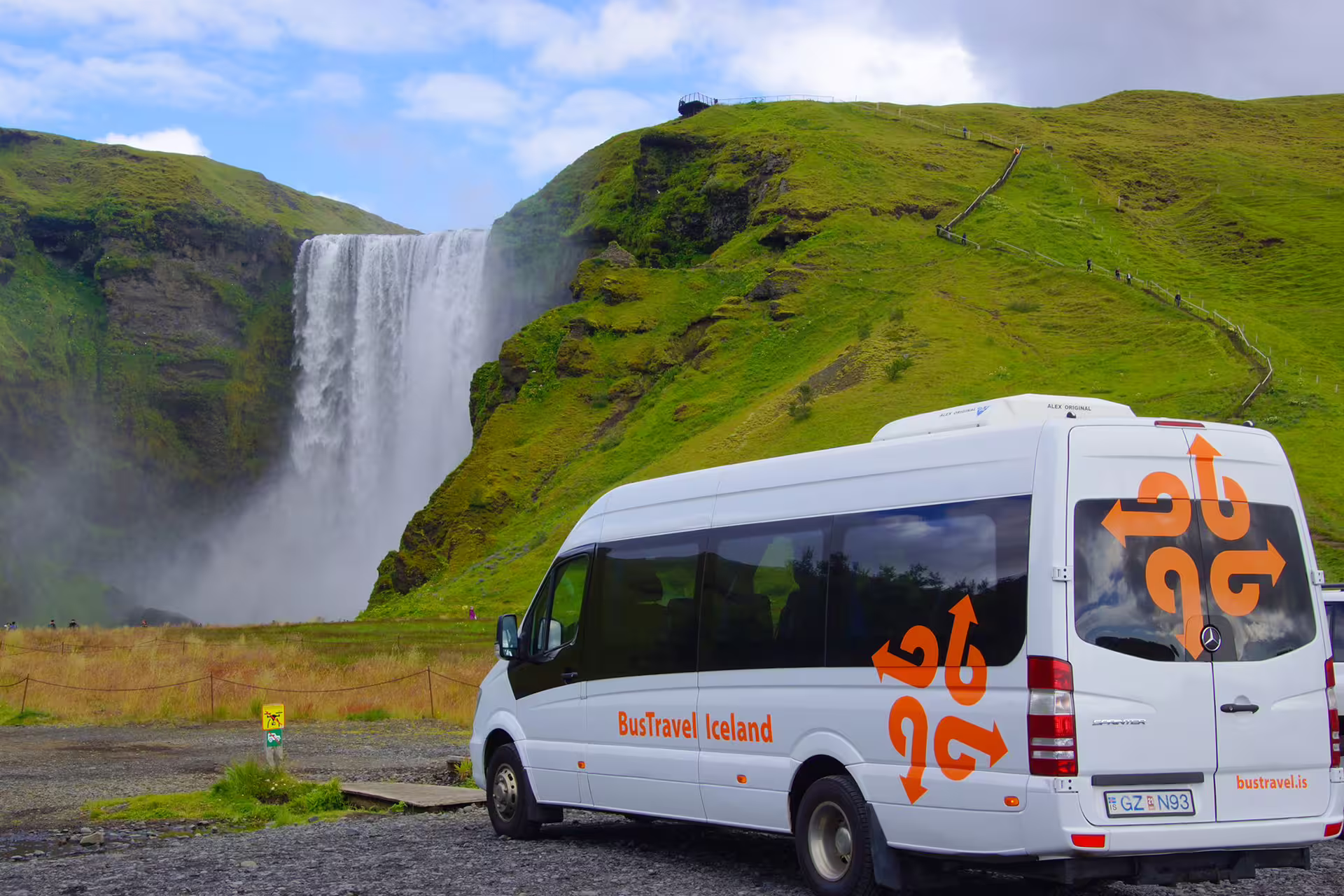 BusTravel Iceland minibus parked at Skógafoss waterfall on Iceland's South Coast tour