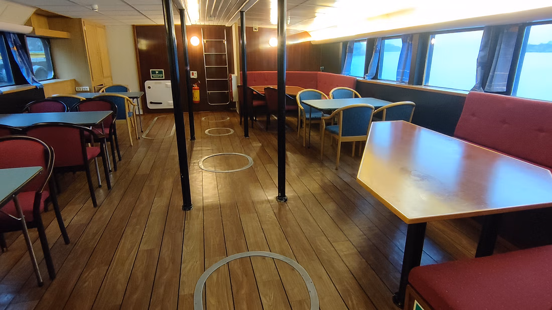 Inside of a boat used to spot whales with a roomy, comfortable seating area