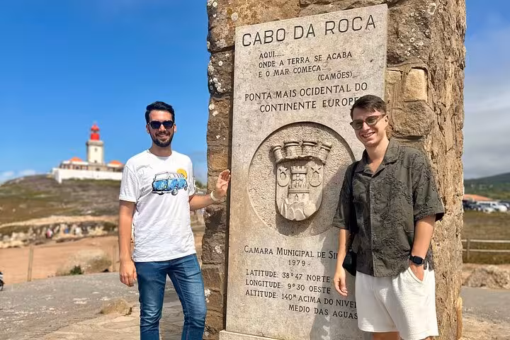 Visitors standing by the Cabo da Roca monument, the westernmost point of Europe, on a Sintra tour adventure.