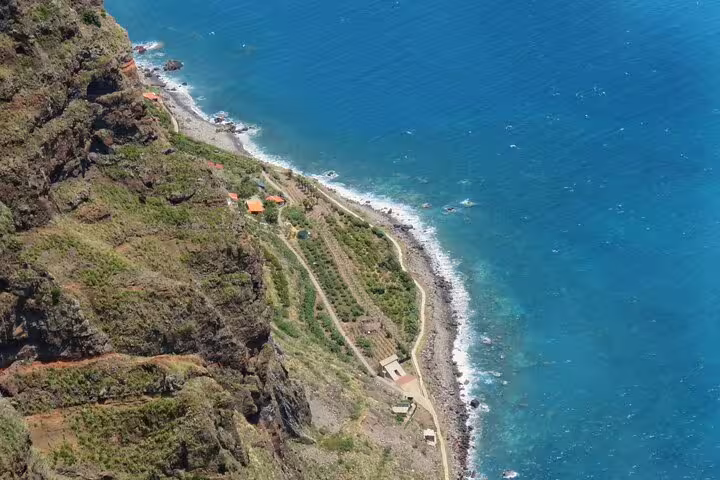 Aerial view of Cabo Girão's dramatic cliffs meeting the azure Atlantic, highlighting Madeira's stunning landscapes on a wine Jeep safari.