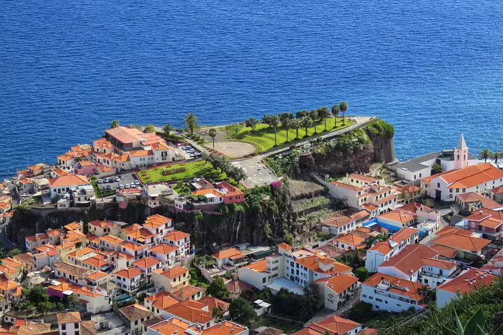 Aerial view of Cabo Girão sea cliff with vibrant village and ocean backdrop, perfect for a 4WD mountain adventure tour.