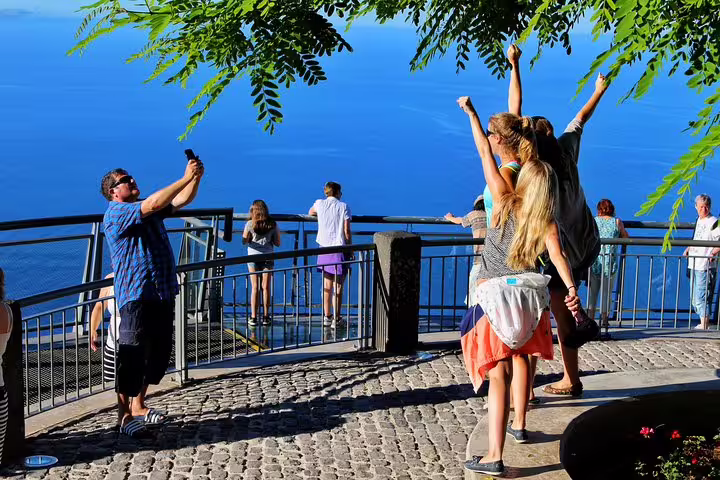 Tourists enjoy breathtaking views from Cabo Girão skywalk, Madeira, during a thrilling 4WD mountain and sea cliff adventure.